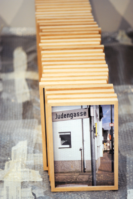 Ein gerahmtes Foto, auf dem ein Straßenschild mit der Aufschrift 'Judengasse' zu sehen ist